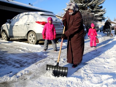 Maryam Farooq helps shovel sidewalks with other members of the Islamic Association of North West Calgary along Ranchview Drive N.W. on Friday, Dec. 25, 2015.