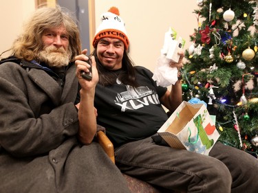 Richard Ritchie, right, and James open gifts at the Calgary Drop-In and Rehab Centre on Dec. 25, 2015.