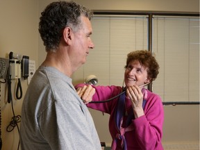 Dr. Margaret Churcher, shown treating longtime patient Phil Page, was named Alberta's doctor of the year by Canada's College of Family Physicians.