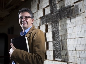 James Paton, lead pastor at First Alliance church, poses by one of the creative walls in the building with his bible, after talking about the Christian idea of charity and giving in Calgary.