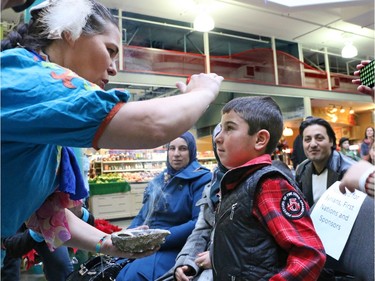 Members of the A-l Khodr family who arrived from Syria on November 30th take part in a native smudge ceremony with Samantha Evan at Eau Claire Market on Thursday. The event was hosted by First Nations members to welcome Syrian refugees on International Human Rights Day.