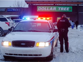 Calgary police members attend the scene of an male who flashed a fake police badge and a fake firearm at the Dollar Tree in Calgary on Monday, Dec. 28, 2015.