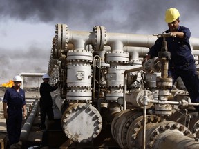 Personnel work at the Rumaila oil refinery, near Basra, Iraq, in this 2009 picture. OPEC's refusal to support prices by controlling output had a major impact on the energy industry in 2015.