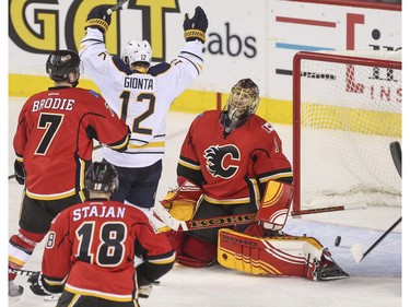 Calgary Flames goalie Jonas Hiller looks defeated as Buffalo Sabres Brian Gionta cheers for the goal scored during game action at the Saddledome in Calgary, on December 10, 2015.