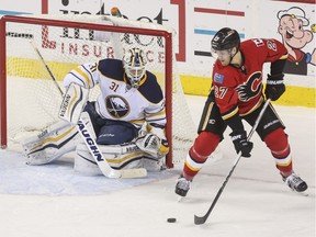 Calgary Flames Dougie Hamilton passes the puck passed Buffalo Sabres goalie Chad Johnson to Calgary Flames Markus Granlund for the assist of the second goal against the Buffalo Sabres at the Saddledome in Calgary, on December 10, 2015.
