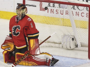 Calgary Flames goalie Jonas Hiller lets this one in off the crossbar during game action against the Buffalo Sabres at the Saddledome in Calgary, on December 10, 2015.