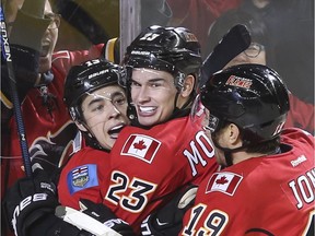 Calgary Flames Johnny Gaudreau, Sean Monahan and David Jones celebrate after scoring the leading and winning goal in the third period during action against the Buffalo Sabres in Calgary, on December 10, 2015.