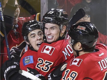 Calgary Flames Johnny Gaudreau, Sean Monahan and David Jones celebrate after scoring the leading and winning goal in the third period during action against the Buffalo Sabres in Calgary, on December 10, 2015.