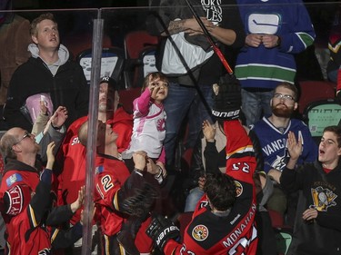 Sean Monahan is awarded first star of the game and gives his stick to a young fan in pink after adding Calgary Flames beat the Vancouver Canucks 3-2 at the Saddledome in Calgary, on February 14, 2015.