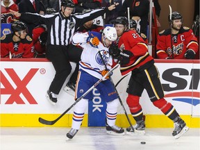 Calgary Flames defenceman Dougie Hamilton collides with Edmonton Oilers left winger Benoit Pouliot at the Scotiabank Saddledome in Calgary on Sunday, Dec. 27, 2015.