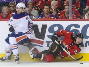 Edmonton Oilers left winger Taylor Hall, left, hits but doesn't stop Calgary Flames centre Sam Bennett from chasing the puck at the Scotiabank Saddledome in Calgary on Sunday, Dec. 27, 2015. The  Calgary Flames won 5-3.