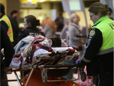 Patients are transported to hospital from the Calgary International Airport in Calgary on Wednesday, Dec. 30, 2015.