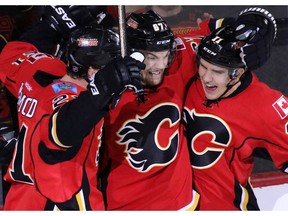 Calgary Flames from left; Mason Raymond, Michael Frolic and Mikael Backlund celebrate Raymond's goal on New York Rangers goaltender Antti Raanta in the second period of NHL action in Calgary on Saturday December 12, 2015.