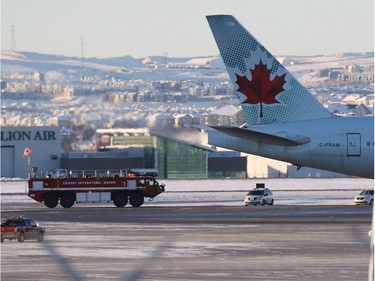 A fire engine follows behind an Air Canada Boeing 777 that was enroute from Shanghai to Toronto but was diverted to Calgary International Airport after several passengers were injured in severe turbulence. (Gavin Young/Calgary Herald)