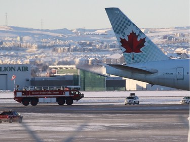 A fire engine follows behind an Air Canada Boeing 777 that was enroute from Shanghai to Toronto but was diverted to Calgary International Airport after several passengers were injured in severe turbulence.