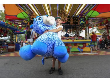 Luiza Kobaczewski, moved from Poland to Canada three months ago and  attending her first stampede, holds a giant blue giraffe that was giving to her by a kind stampeder on July 10, 2015.