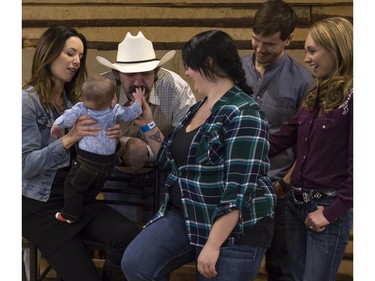 Kaiden Viney, 7 months, is held by Michelle Morgan (Lou Fleming), and runs his little baby fingers through the moustache of Shaun Johnston (Jack Bartlett), as he and his mom Amy Davidson, centre, get their photos taken with some of the cast of CBC's hit TV show, Heartland, including Amber Marshall (Amy Fleming), Graham Wardle (Ty Borden), Jessica Steen (Lisa Stillman), and Alisha Newton (Georgie), in support of HomeFront's 'Cool It, Calgary' campaign at the Symons Valley Ranch market in Calgary, on December 12, 2015.