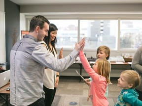 Stephanie Wong, founder and manager of Helping Hoc, and Chris Somerville, Marketing Manager of Helping Hoc get a congratulatory high five from supporter Kate Kucharski, 10, at a fundraising event earlier this year.