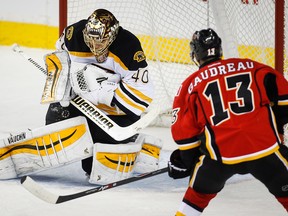 Boston Bruins goalie Tuukka Rask, left, from Finland, grabs a shot from Calgary Flames Johnny Gaudreau during second period NHL hockey action in Calgary, Monday, Feb. 16, 2015.