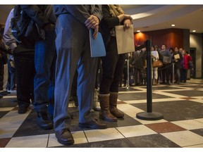 Hundreds wait in line to attend the Hire10, a hiring initiative that matches hiring companies with job seekers, job fair at the Metropolitan Centre in Calgary, on December 17, 2015.