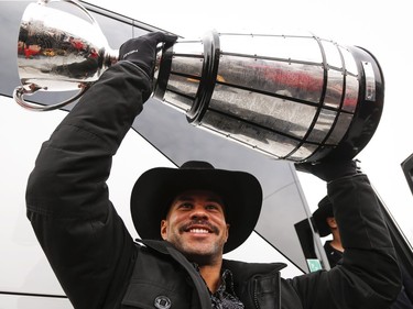 Calgary Stampeders Jon Cornish lifts the Grey Cup as he returns to Calgary, Monday, Dec. 1, 2014, after defeating the Hamilton Tiger-Cats to win the 102nd Grey Cup.