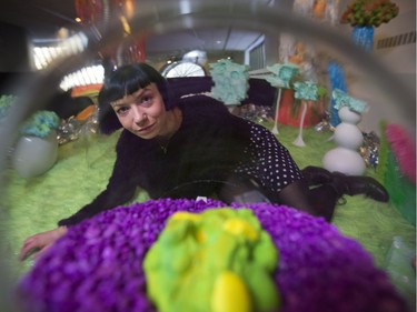 Sasha Foster looks through one of her glass bowl pieces at her "Far Out" art installation at the Ledge Gallery at Arts Common in Calgary, on December 16, 2015.
