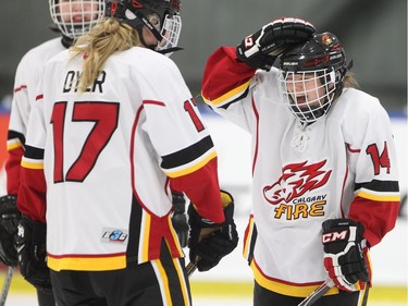 Courtney Kollman, right,  of the Calgary Fire has a laugh with teammate Meg Dyer, 17, in their opening female division game against Edmonton Thunder at the annual Macs Midget Tournament Boxing Day morning December 26, 2015 at Max Bell Arena.