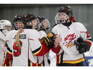 Calgary Fire players, from the left, Jessica Squires, Isabel Johnson, Kayka Likuski, and Audrey Buston, celebrate their victory over the  Edmonton Thunder in the opening female division game at the annual Macs Midget Tournament Boxing Day morning December 26, 2015 at Max Bell Arena.