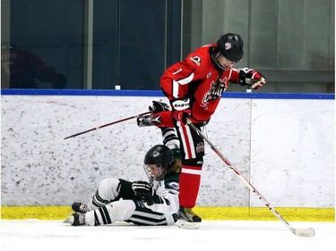 Capitals Victoria Byer, 7 red, gets untangled from Wild Maddie Vockeroth-Fisher, 10, in the second period.  The Northern Capitals were playing the Kootaney Wild on December 28, 2015 in the Mac's Midget Tournament rink 2.