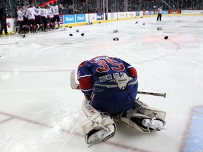 Regina Pats Canadians goalie Curtis Meger slumped on the ice as members of the Cariboo Cougars celebrated after winning the Max's AAA Midget Tournament male final 2-1 in double overtime at the Scotiabank Saddledome on January 1, 2015. Meger has been suspended for two games in this year's tournament.