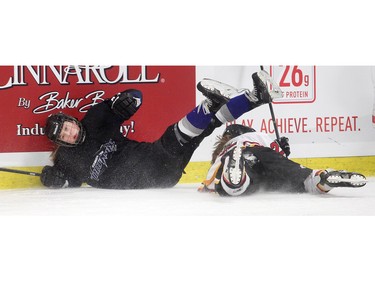 Jessica Van Os of the Edmonton thunder tumbles ito the boards after colliding with Laura Jardin, left, of the Calgary Fire in the opening female division game at the annual Macs Midget Tournament Boxing Day morning December 26, 2015 at Max Bell Arena.