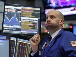 Specialist Meric Greenbaum works at his post on the floor of the New York Stock Exchange.