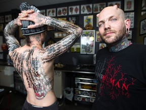 Matthew Menczyk, left, is pierced by Russ Foxx in an attempt to gain the Guinness World Record for "The Most Surgical Needle Piercings In One Session" at Human Kanvas in Calgary on Tuesday, December 22, 2015. Menczyk undertook the attempt in support of Calgary charity Inn from the Cold. Over nine hours 4,745 needles were inserted.