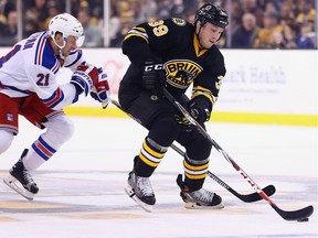 Derek Stepan #21 of the New York Rangers defends Matt Beleskey #39 of the Boston Bruins during the first period at TD Garden on November 27, 2015 in Boston, Massachusetts.