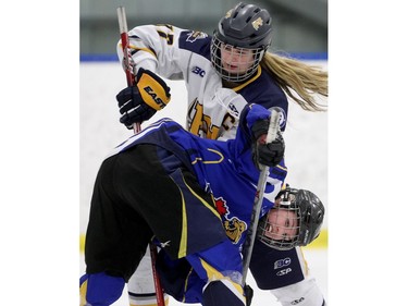 Kenzie Robinson of the Westman Wildcats gets caught under Fraser Valley Rush captain Paige Savard during the Mac's Midget Tournament Wednesday December 30, 2015 at Max Bell Arena.