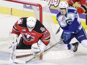 Calgary Hitmen netminder Cody Porter, left, blocks a shot from Swift Current Broncos' Cavin Leth of Taber on Sunday.