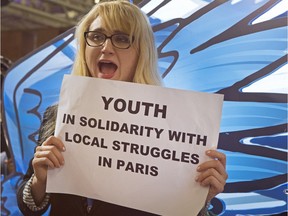 Sarabeth B. Brockley, from New York, holds a poster among NGO representatives and participants staging a sit-in protest closed to the plenary session to denounce the first draft COP21 Climate Conference agreement, and put pressure to reach an international agreement to limit global warming, during the COP21, United Nations Climate Change Conference.