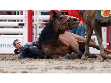 There were a few scary moments when a horse named Twin Cherry went down while carrying Orin Larsen, from Inglis MB on him. Lots of help rushed in to free the cowboy from the horse and they were both unhurt after in incident in the bareback event at the Stampede finals on July 12, 2015.