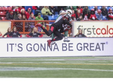 Calgary Stampeders Brandon McDonald and Saskatchewan Roughriders Ryan Smith jump to reach for the pass during game action at McMahon Stadium in Calgary, on October 31, 2015.