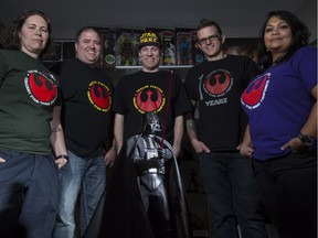 Star Wars super fans Marcy Deklerck, from left, Ryan Manson, Ryan Dooks, Greg Tidlund, and Yrol Perera-Murney, pose for a photo with a Darth Vader surrounded by Star Wars collectibles at one of their homes in Calgary, on December 10, 2015. The group chatted excitedly about being in line early to get good seats when the movie opens in Calgary.