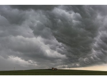 A chinook storm cloud is photographed above a lone house in a field northwest of Calgary, on June 19, 2015.