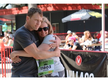 Heath McCoy, husband of Tamara Gignac a Herald reporter who died of Cancer on Friday, gets a hug from Leanne Dohy as friends and family prepared to walk/run in her honour at the 5 km portion of the Scotiabank Marathon.