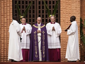 Pope Francis prays before the "Holy Door" at Bangui Cathedral in the Central African Republic ahead of the start of a Catholic Jubilee Year, marking forgiveness and reconciliation on November 29, 2015. "Open for us the gate of your mercy," the 78-year-old pope prayed before opening the door.