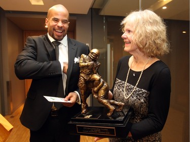 Calgary Stampeders running back Jon Cornish showed his mother Margaret Cornish the trophy after he was named the Most Outstanding Canadian  Player.