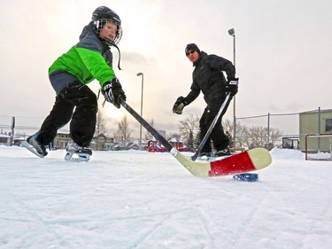 Owen Palmer, 9, and dad Trevor play some hockey on the Renfrew community ice rink on Monday December 28, 2015.