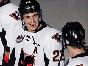 Calgary Hitmen Taylor Sanheim talks with teammate Colby Harmsworth before the start of their game against the Kootenay Ice on Monday December 28, 2015. Sanheim wears an 'A' assistant captain jersey in the absence of his brother Travis who is at the World Juniors.