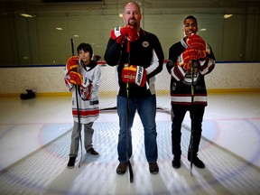 Kevin Hodgson, director of program development for Hockey Education Reaching Out Society, middle, with Blaze Prairie Chicken, 12, and Malik Walker, 18, at Ernie Starr Arena in Calgary.