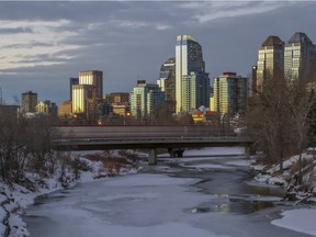 A sunset view of the Calgary downtown skyline, as the C-train crosses a bridge over the Elbow River, in Calgary, on January 7, 2015.