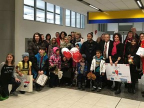 The Al Saeid family, refugees of the Syrian war, and members of the Calgary group that sponsored their refugee application in Canada. meet for the first time at the Calgary airport Sunday. (Handout photo)