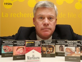 Rob Cunningham, Senior Policy Analyst, Canadian Cancer Society, holds some cigarette packaging from Australia.  (Jean Levac/ Ottawa Citizen)